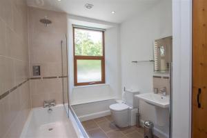 uma casa de banho com uma banheira, um WC e um lavatório. em Robins Nest em Coniston