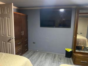 a bedroom with a bed and a large television on the wall at KALOM in Creel