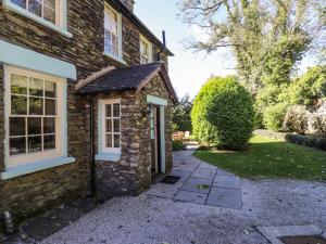 a stone house with a pathway leading to the door at Jessicas Cottage in Bowness-on-Windermere