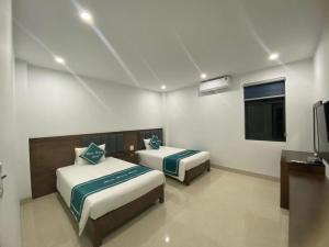 Cette chambre comprend 2 lits et une télévision. dans l'établissement Minh Hưng Motel, à Hạ Long