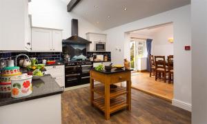 uma cozinha com armários brancos e um forno com placa de fogão em Ellerthwaite House em Windermere