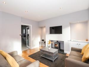 ein Wohnzimmer mit Couch und Kamin in der Unterkunft Lakestone Cottage in Windermere