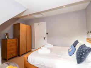 ウィンダミアにあるLakestone Cottageのベッドルーム1室(ベッド1台付)、木製キャビネットが備わります。