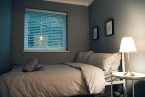 een slaapkamer met een bed en een raam bij Modern 2 Bed Apartment Near City Centre in Chelmsford
