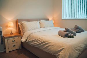 - une chambre avec un lit avec deux animaux rembourrés dans l'établissement Modern 2 Bed Apartment Near City Centre, à Chelmsford