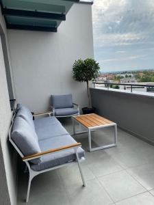 a balcony with two chairs and a table on a building at Arena ZG Apartment in Zagreb