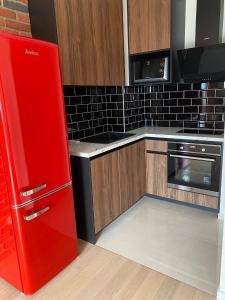 a red refrigerator in a kitchen with wooden cabinets at Arena ZG Apartment in Zagreb
