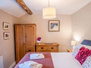 1 dormitorio con 1 cama y armario de madera en Knotts Cottage, en Windermere