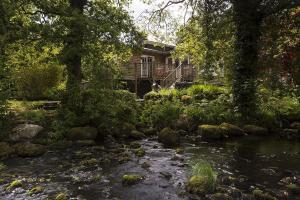 une maison avec une rivière en face d'une maison dans l'établissement Rosewood by the River, à Ambleside