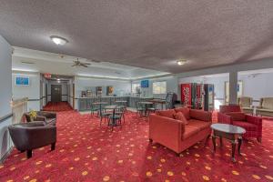 a large room with couches and chairs and tables at American Inn & suites in Dundee