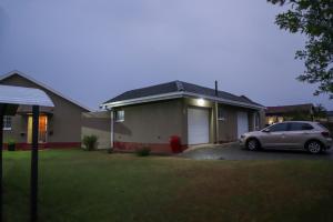 a house with a car parked in the driveway at Delux Guesthouse in Volksrust