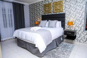 a bedroom with a large bed with two towels on it at Delux Guesthouse in Volksrust