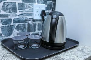 a coffee maker and two cups on a black tray at Delux Guesthouse in Volksrust
