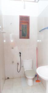 a bathroom with a toilet and a sink at V6 Holiday Bungalow in Badulla