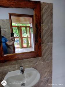 una mujer tomando una foto de sí misma en un espejo del baño en Casa kumake en El Zaino