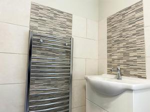 ein Bad mit einem Waschbecken und einer Dusche in der Unterkunft On Trend 3 Bedroom Home In Maerdy near Attractions 