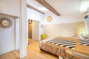 1 dormitorio con 1 cama y reloj en la pared en 'Les Arsenaux' Studio de charme coeur de Marseille by Weekome en Marsella