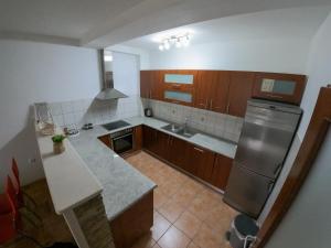 a kitchen with wooden cabinets and stainless steel appliances at Apartman City Center AN Trebinje in Trebinje