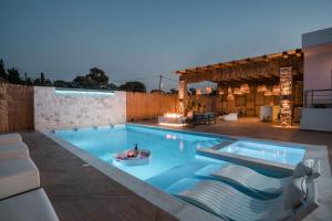 a swimming pool with lounge chairs in a house at Le Ialyse Luxury Villa in Ialysos