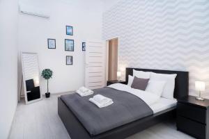 a bedroom with a large bed with two towels on it at Central and New design apartment in Budapest