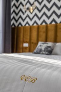 um close-up de uma cama com a palavra des sobre ela em Hotel Vila Central Boutique Satu Mare em Satu Mare