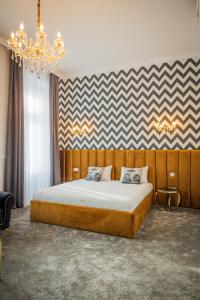 - une chambre avec un grand lit et un lustre dans l'établissement Hotel Vila Central Boutique Satu Mare, à Satu Mare