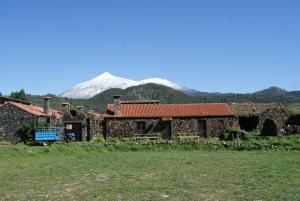 San Jose De Los Llanos卡塞里奥洛杉帕特多斯乡村民宿的一座古老的石头建筑,背景是一座山