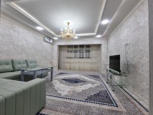 a living room with a couch and a television at APARTMENT “NOVZA” in Tashkent
