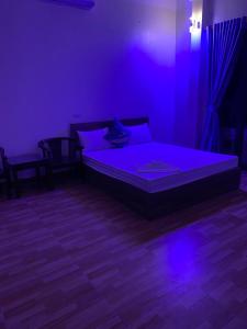 a bedroom with a bed in a purple room at Nhà Nghỉ Hương Trà 2 Tân Phú 