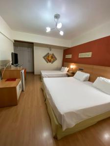a hotel room with two beds and a television at Líber Hotel Nova Serrana - Conforto na Rota da BR-262 in Nova Serrana +38 photos
