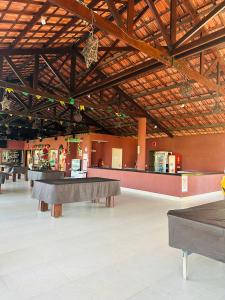 een grote kamer met tafels in het midden van een gebouw bij Apartamento Aquaville Resort in Aquiraz