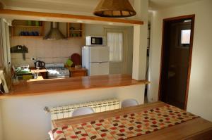 a kitchen with a counter with chairs and a refrigerator at Valle del Molino in Trevelin