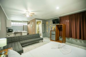 sala de estar con cama y cocina en Coati Arenal Lodge en Fortuna