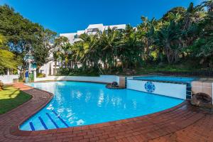a swimming pool with blue water in a resort at Santorini - Perissa 41 in Ballito