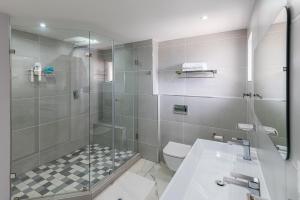 a bathroom with a shower and a toilet and a sink at Santorini - Perissa 41 in Ballito