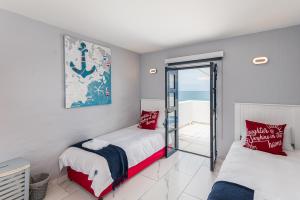 two beds in a room with a view of the ocean at Santorini - Perissa 41 in Ballito