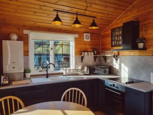a kitchen with a sink and a table in it at Cabins at Old Pier House in Fort Augustus