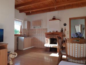 a kitchen with a fireplace and a table and a chair at Vikendica Kristina in Prijedor
