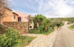 a house with a stone wall next to a street at Trilo Sup in Trinità d'Agultu e Vignola