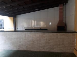- une cuisine avec du carrelage blanc sur le mur dans l'établissement Pousada Paraiso Guarapari, à Guarapari