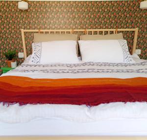 un letto con due cuscini sopra in una camera da letto di Cactus - צימר במדבר ad Arad