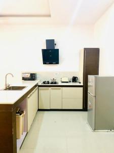a kitchen with a sink and a refrigerator at Luxury Comfortable One Bedroom In Lekki Phase1 in Lekki