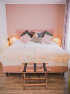 a bedroom with a large bed with two benches at Tante ALMA's Mülheimer Hotel in Mülheim an der Ruhr