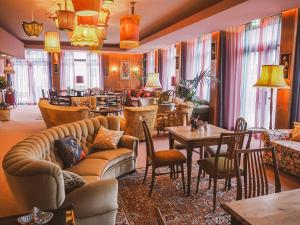 sala de estar con sofá, mesas y sillas en Tante ALMA's Mülheimer Hotel en Mülheim an der Ruhr