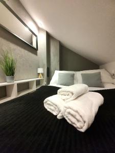 a bedroom with a bed with white towels on it at SzafranSKI Saneczkowa Apartment in Karpacz