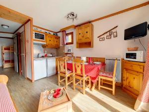 a kitchen and dining room with a table and chairs at Appartement Les Menuires, 2 pièces, 4 personnes - FR-1-344-867 in Les Menuires