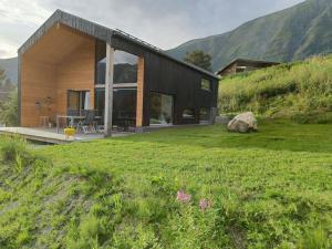 a house on a hill with a green yard at Huset ved skogen in Isfjorden