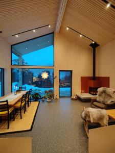 een woonkamer met een tafel en stoelen en een groot raam bij Huset ved skogen in Isfjorden