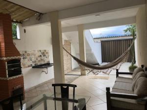 a living room with a hammock in a house at Flats Ponta do Sapê in Angra dos Reis