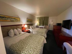 a hotel room with two beds and a flat screen tv at Days Inn by Wyndham Deming in Deming